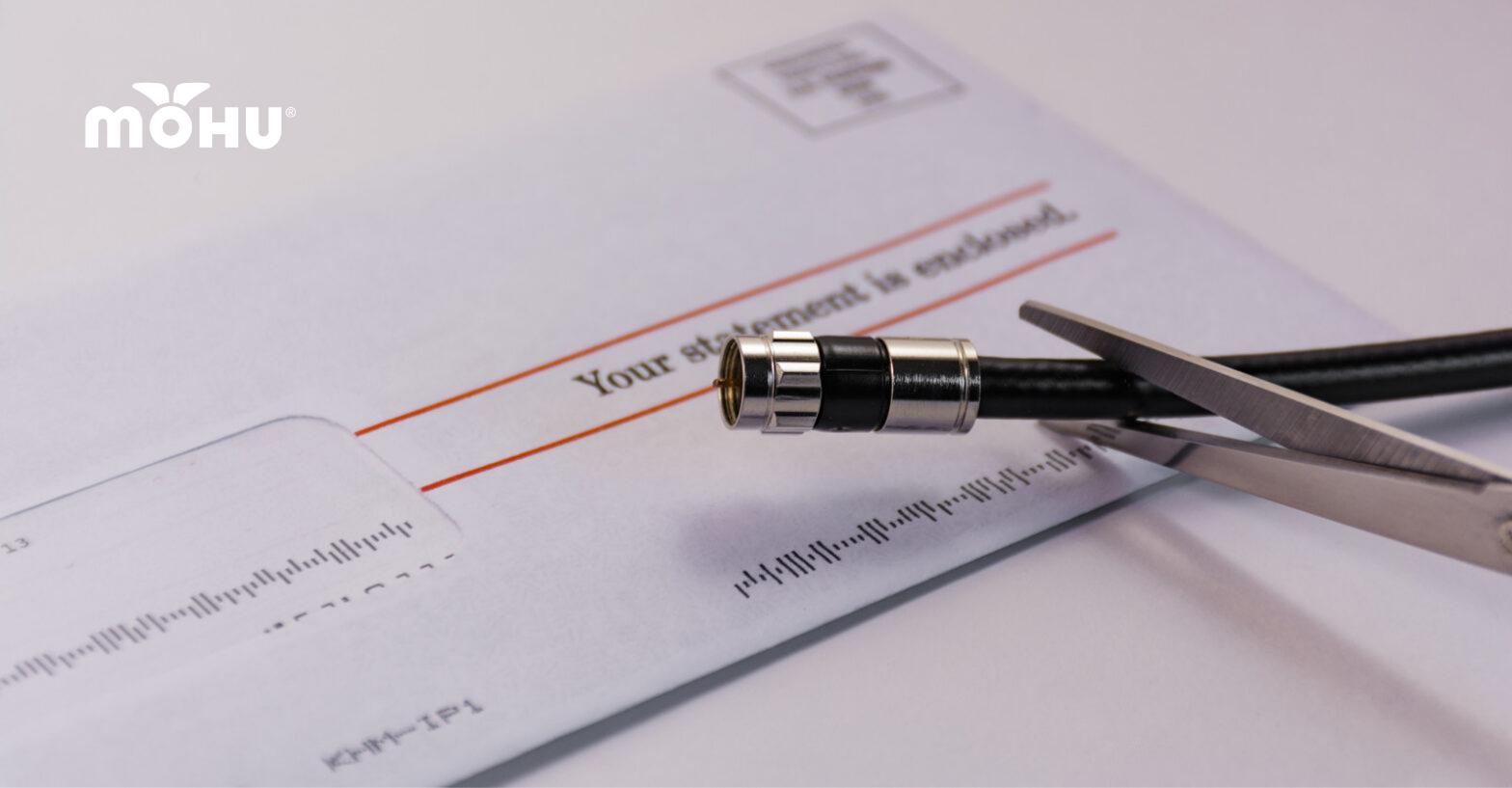 Scissors cutting coaxial cable over a cable bill with Mohu logo